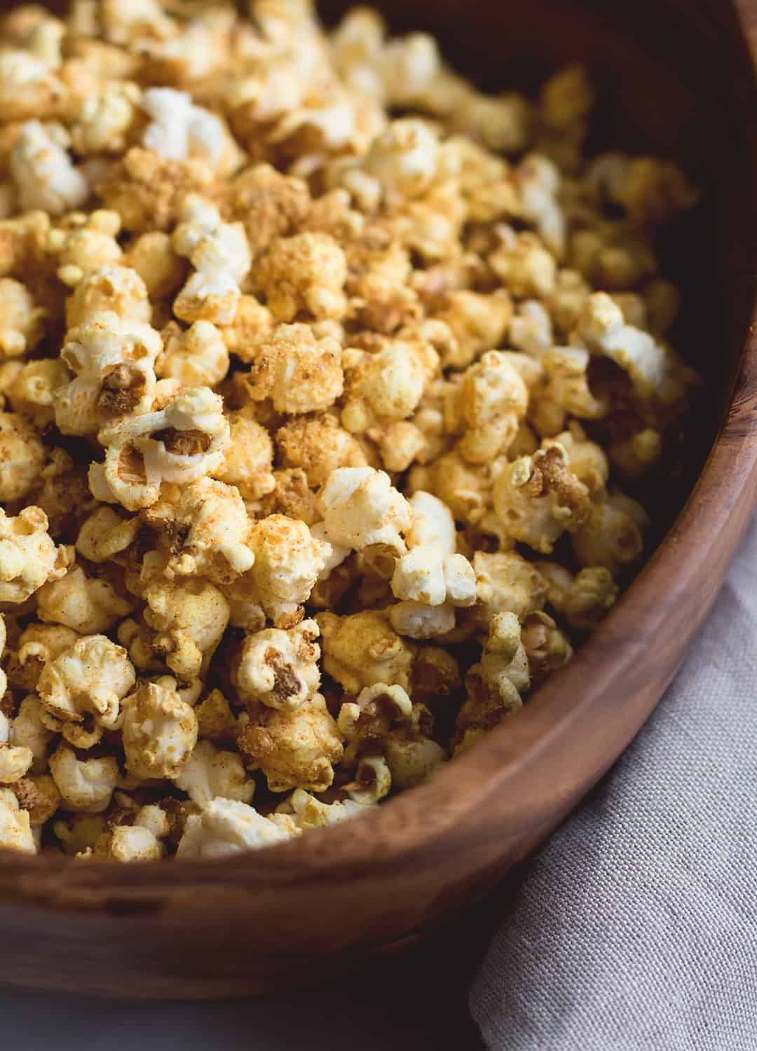 Cheesy Vegan Popcorn - a delicious healthy twist on the classic. Popped the old-fashioned way on the stove with coconut oil and then spiced to perfecting. Ridiculously easy to make! | thehealthfulideas.com