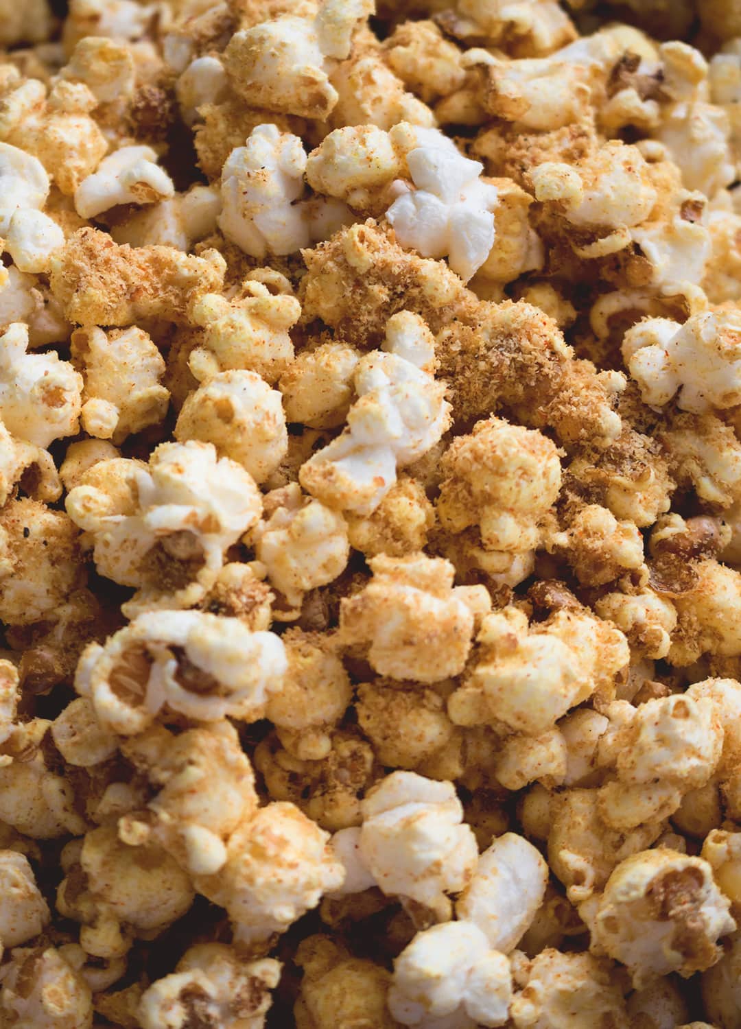 Cheesy Vegan Popcorn - a delicious healthy twist on the classic. Popped the old-fashioned way on the stove with coconut oil and then spiced to perfecting. Ridiculously easy to make! | thehealthfulideas.com
