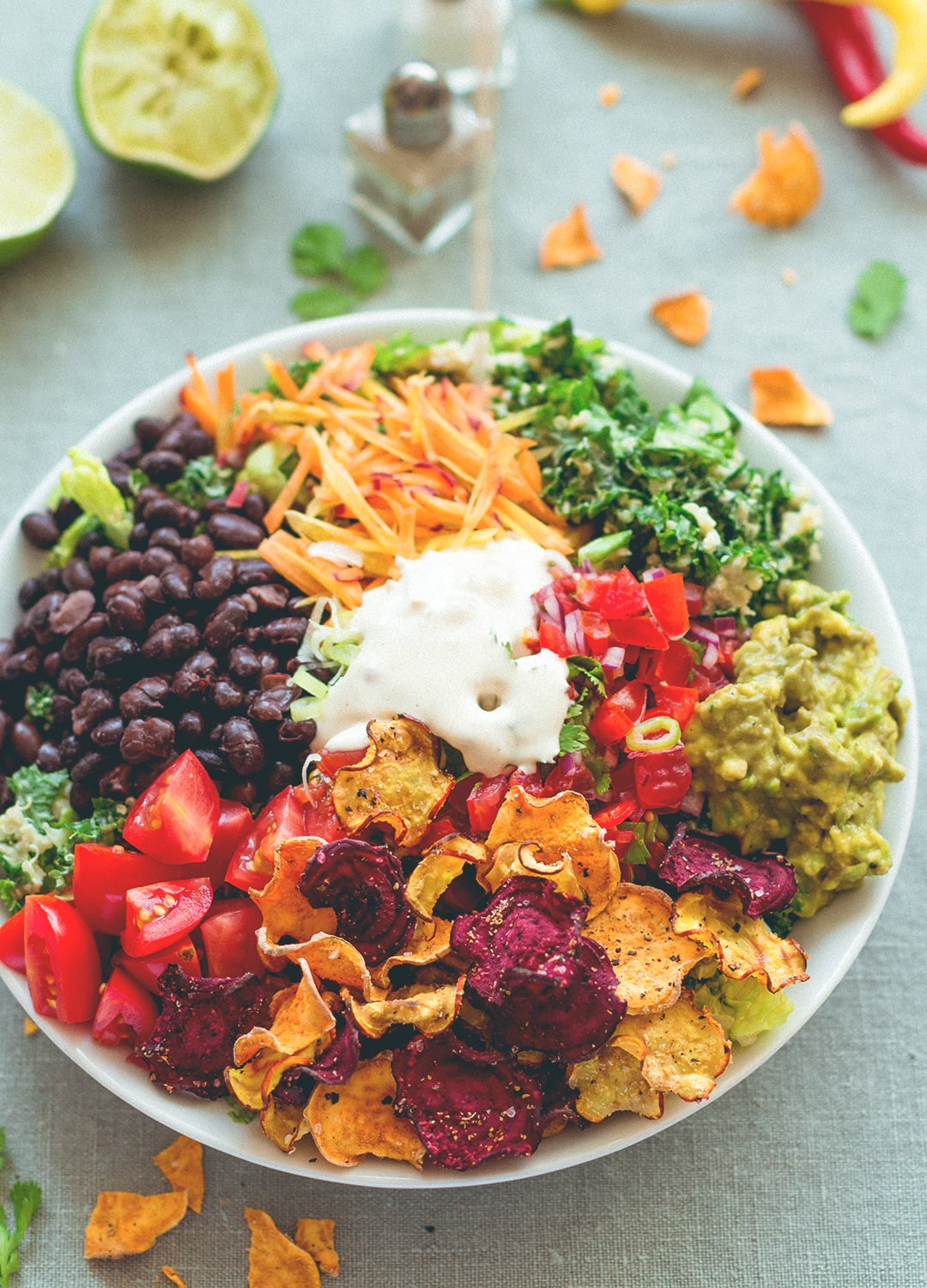 Mexican Kale Salad with Cashew Dressing aka the best salad in the world. Kale, black beans, spicy salsa, guacamole, cherry tomatoes, carrots, veggie chips, and amazing cashew dressing! | thehealthfulideas.com