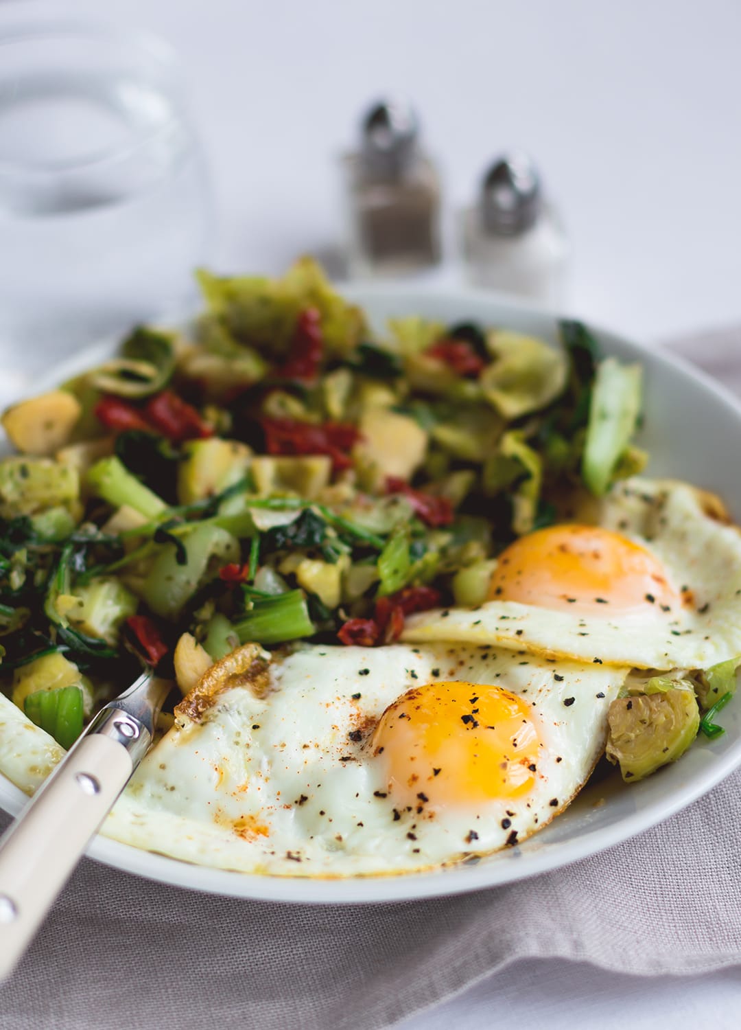Sauteed pak Choy and Brussels Sprouts with Eggs Sunny Side Up - this is the ultimate savory breafast for a morning when you have a little bit more time to spend in the kitchen. It's probably my most favorite savory breakfast, because it includes eggs and all things green (I also sneaked in some baby spinach for even more of a healthy kick!) . I love to pair this with avocado on toast. | thehealthfulideas.com