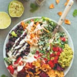 Mexican Kale Salad with Cashew Dressing aka the best salad in the world. Kale, black beans, spicy salsa, guacamole, cherry tomatoes, carrots, veggie chips, and amazing cashew dressing! | thehealthfulideas.com