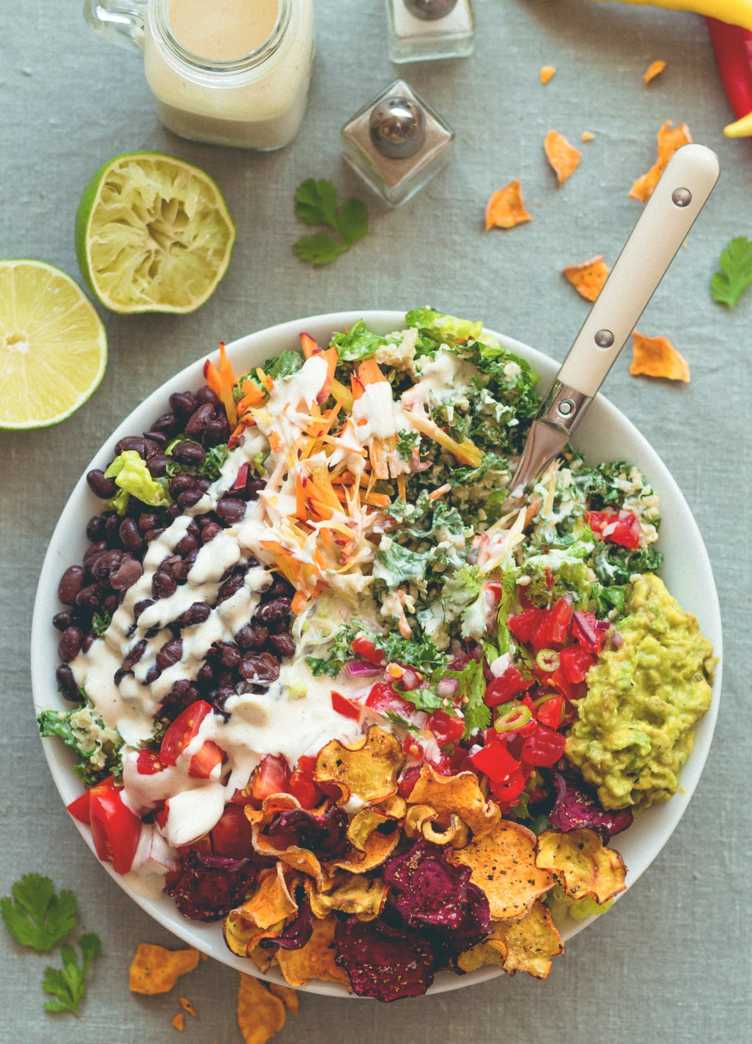 Mexican Kale Salad with Cashew Dressing aka the best salad in the world. Kale, black beans, spicy salsa, guacamole, cherry tomatoes, carrots, veggie chips, and amazing cashew dressing! | thehealthfulideas.com