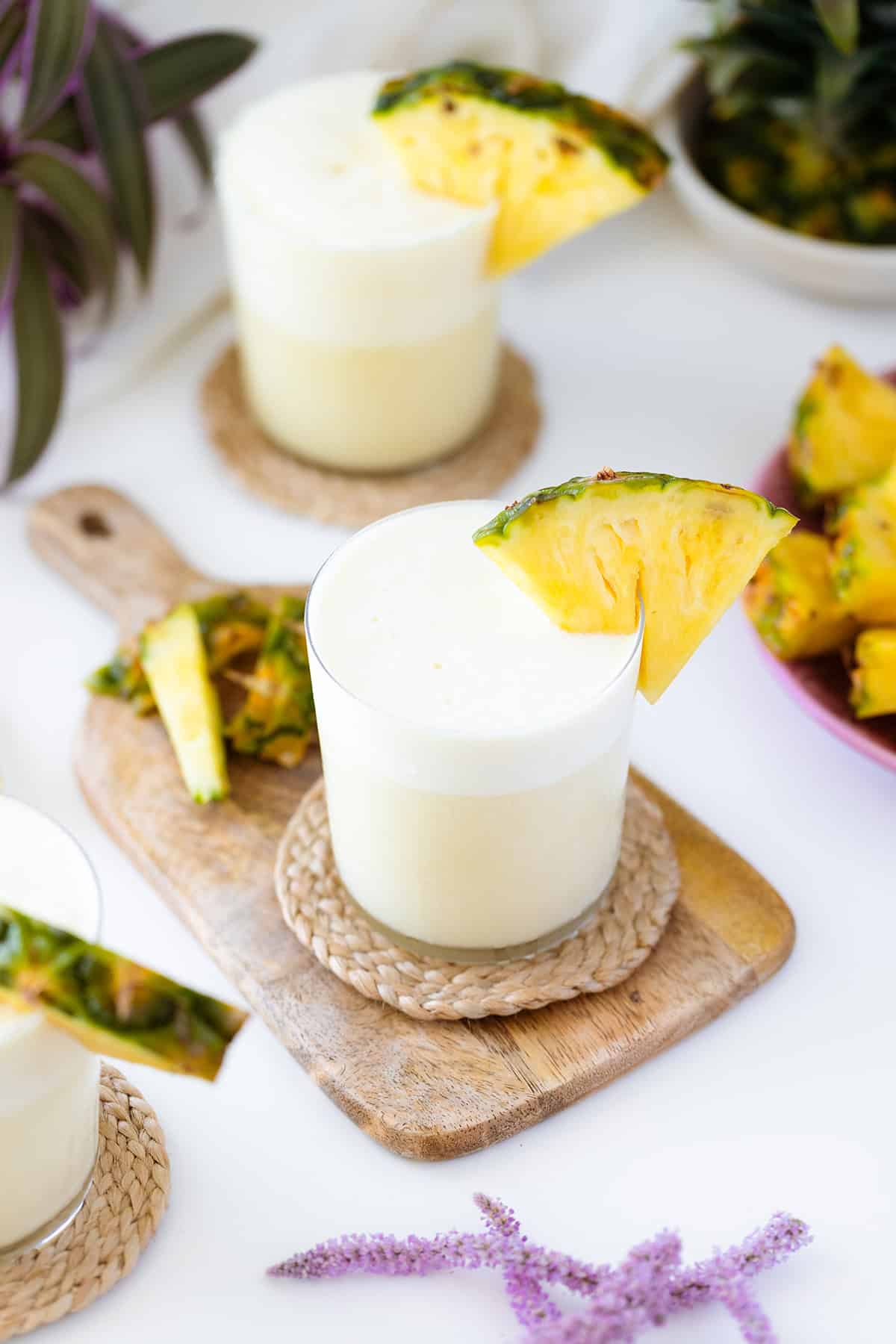 An overhead shot of Skinny Pina Colada cocktails decorated with pineapple on a while table