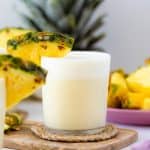 A head on shot of Skinny Pina Colada cocktail decorated with pineapple on a while table