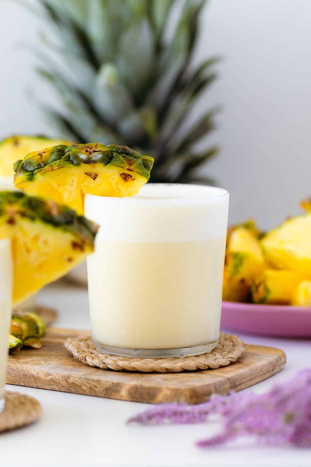 A head on shot of Skinny Pina Colada cocktail decorated with pineapple on a while table