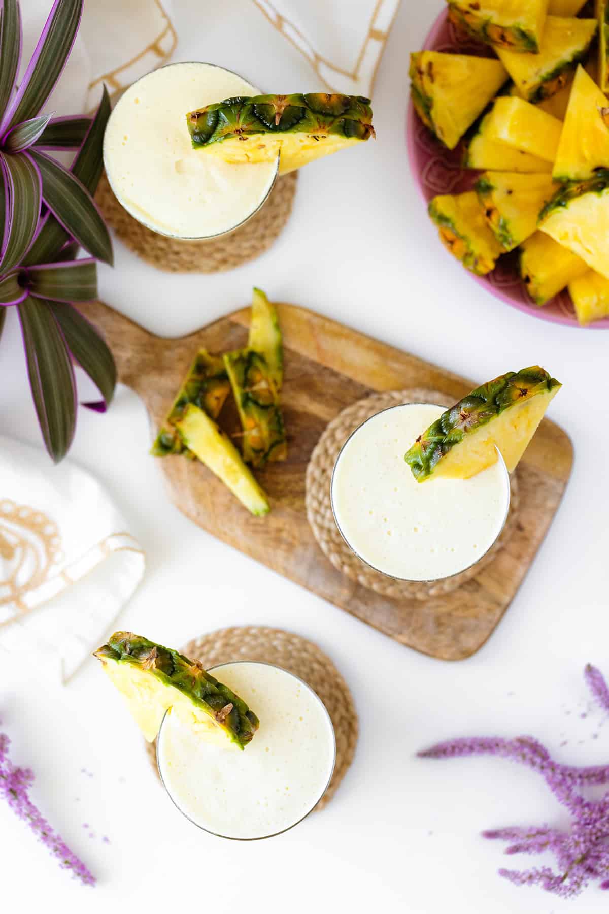 An overhead shot of Skinny Pina Colada cocktails decorated with pineapple on a while table