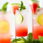 Watermelon Coconut Rum Cooler - three glasses in shot, head on, decorated with mint, lime, and watermelon slice
