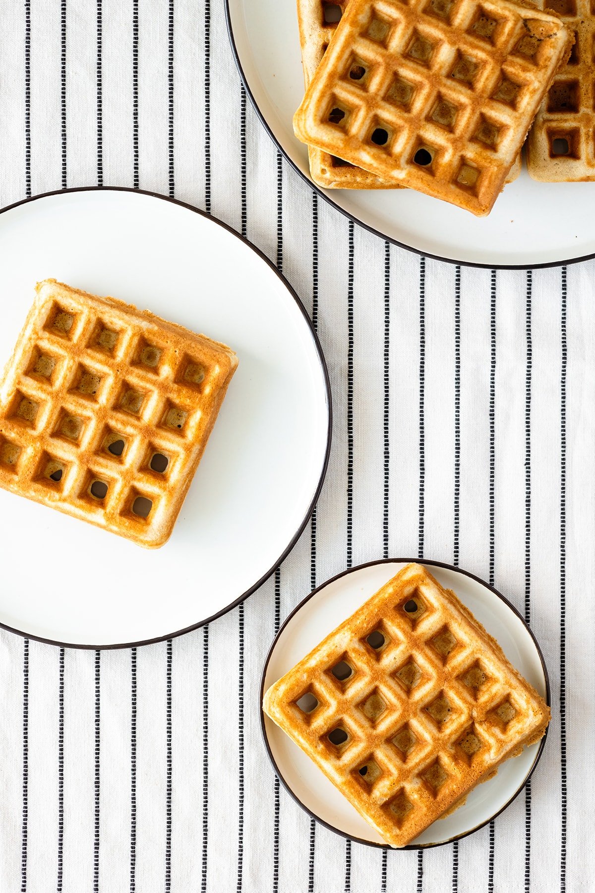 Basic Gluten-free Waffles on a white plate and a white table cloth with black stripes