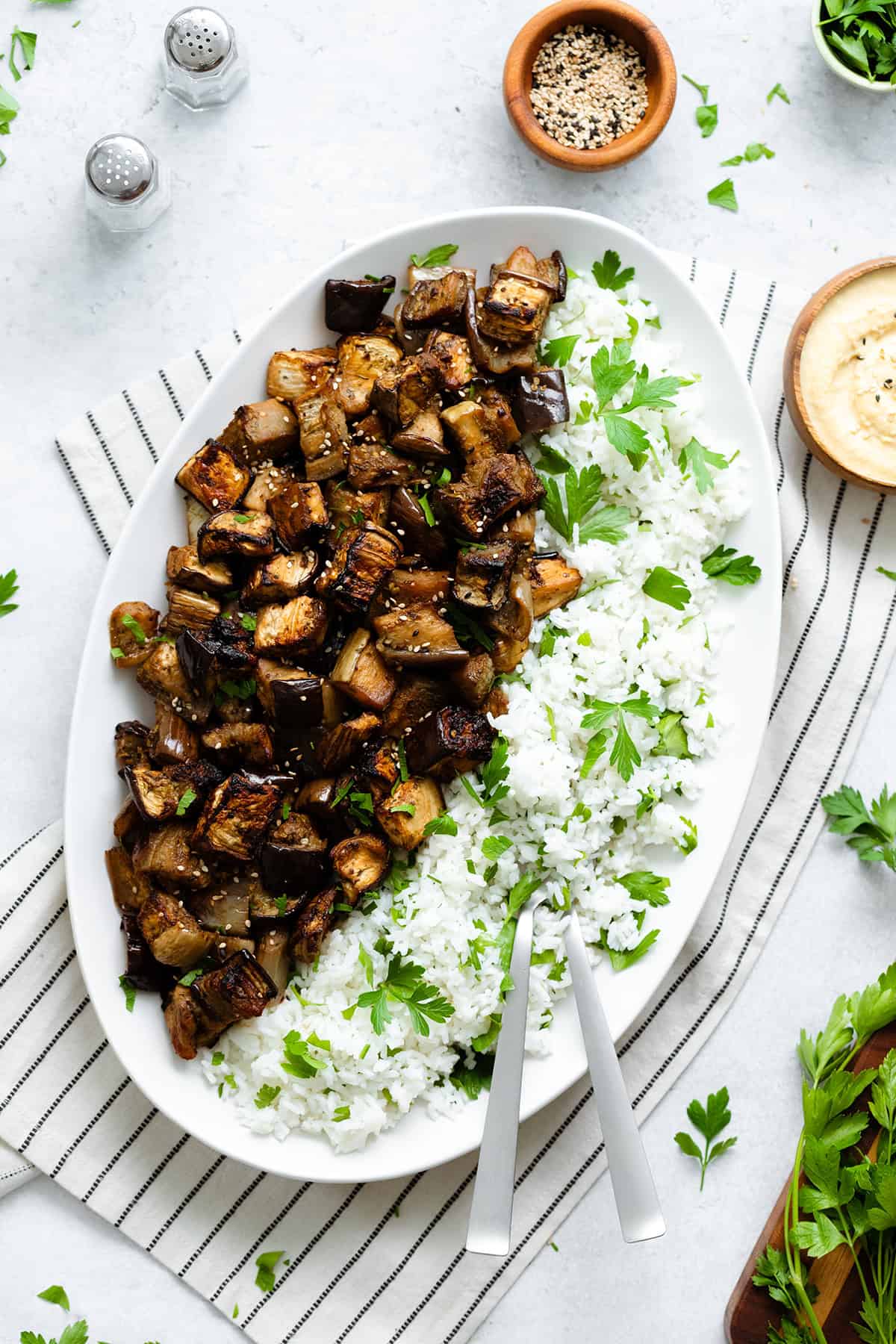 Spicy Garlic Miso Roasted Eggplant with white basmati rice and a sprinkle of parsley on a big oval plate