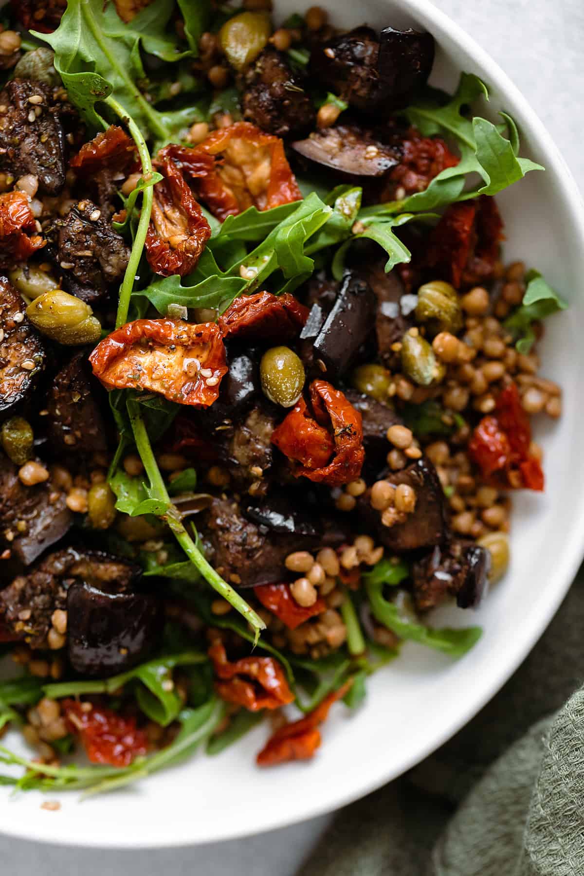 Za'atar Roasted Eggplant Lentil Salad with Sundried Tomatoes in white bowl close up