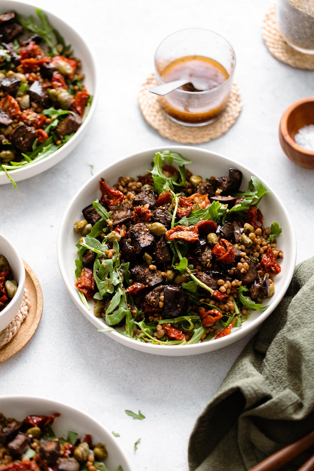 Za'atar Roasted Eggplant Lentil Salad with Sundried Tomatoes in white bowl on a grey background