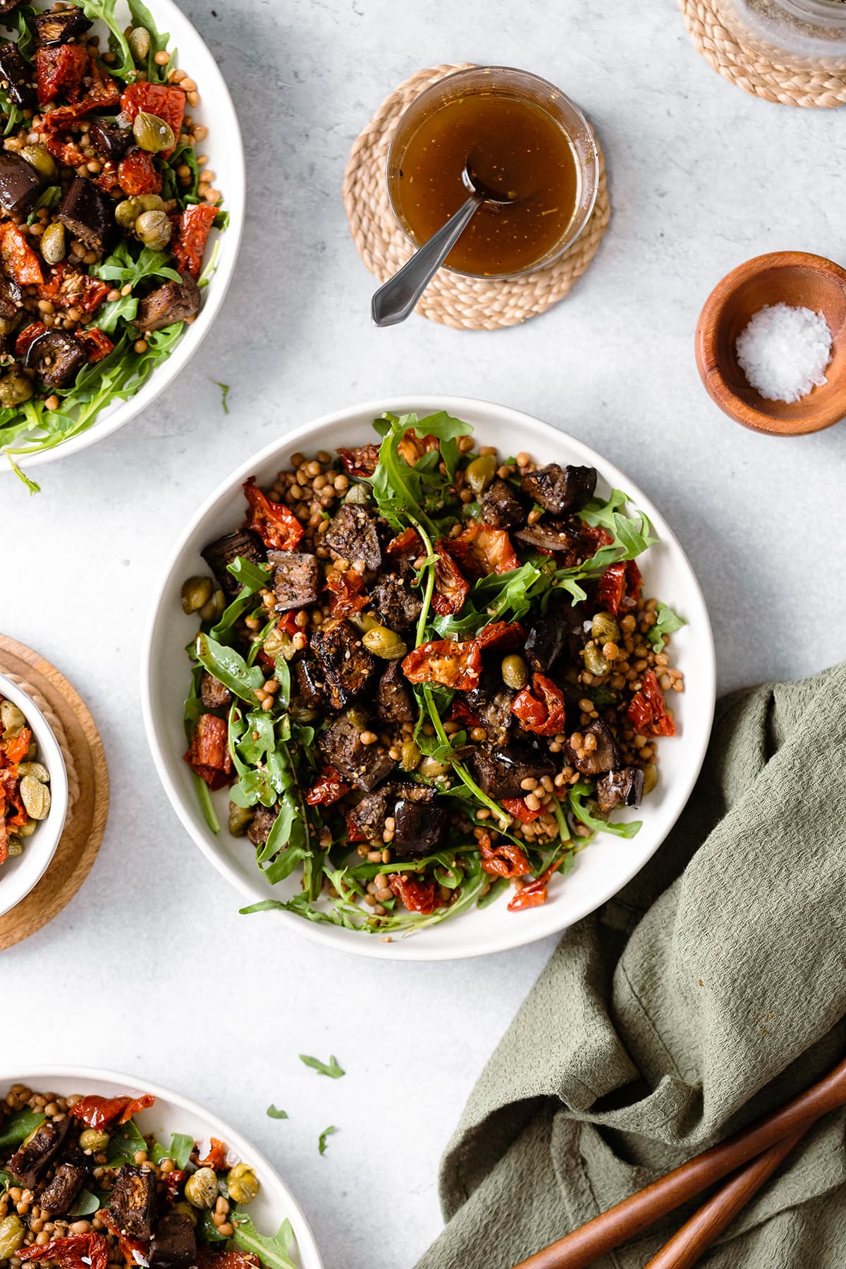 Za'atar Roasted Eggplant Lentil Salad with Sundried Tomatoes in white bowl on a grey background