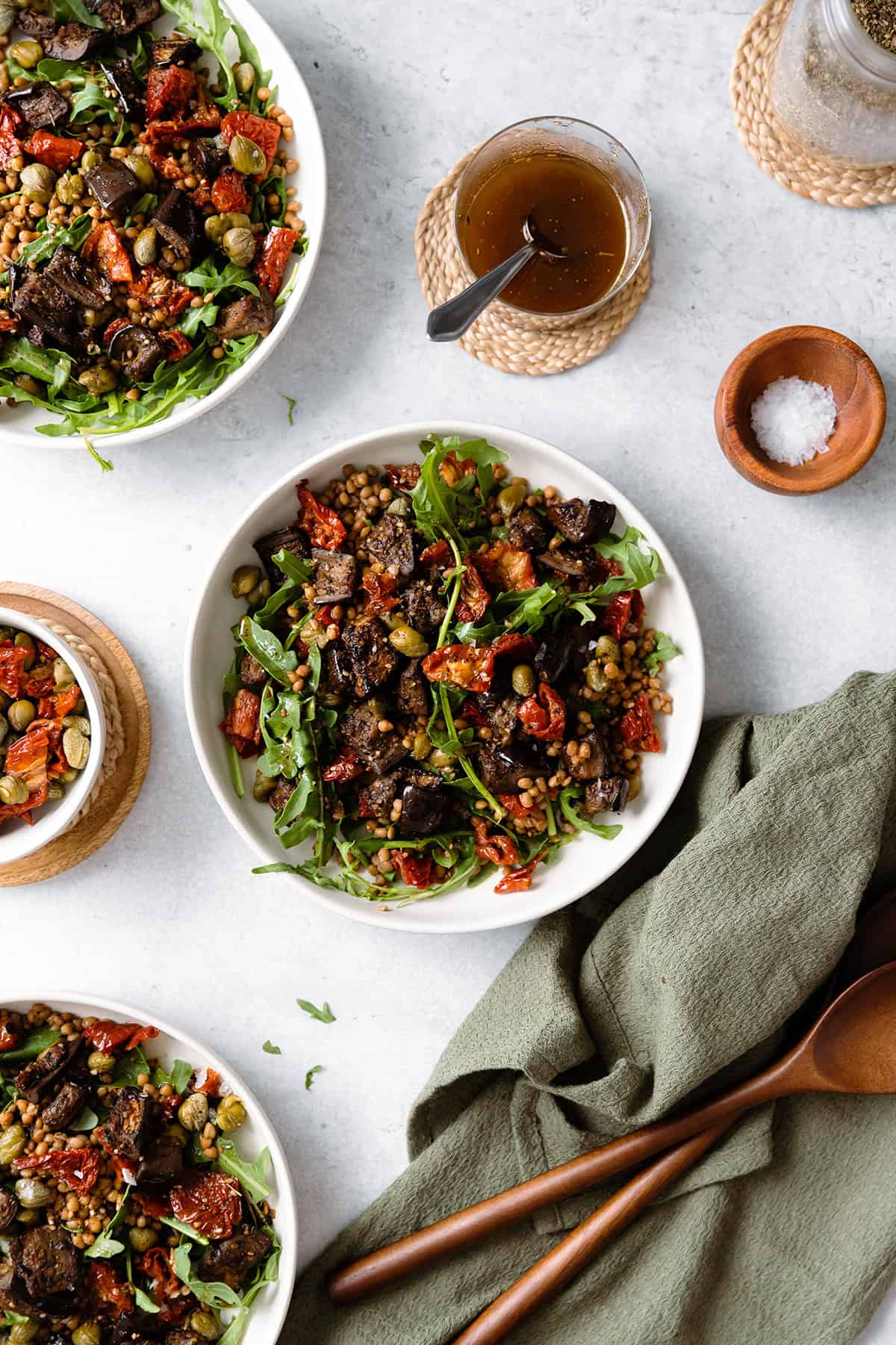 Za'atar Roasted Eggplant Lentil Salad with Sundried Tomatoes in white bowl on a grey background