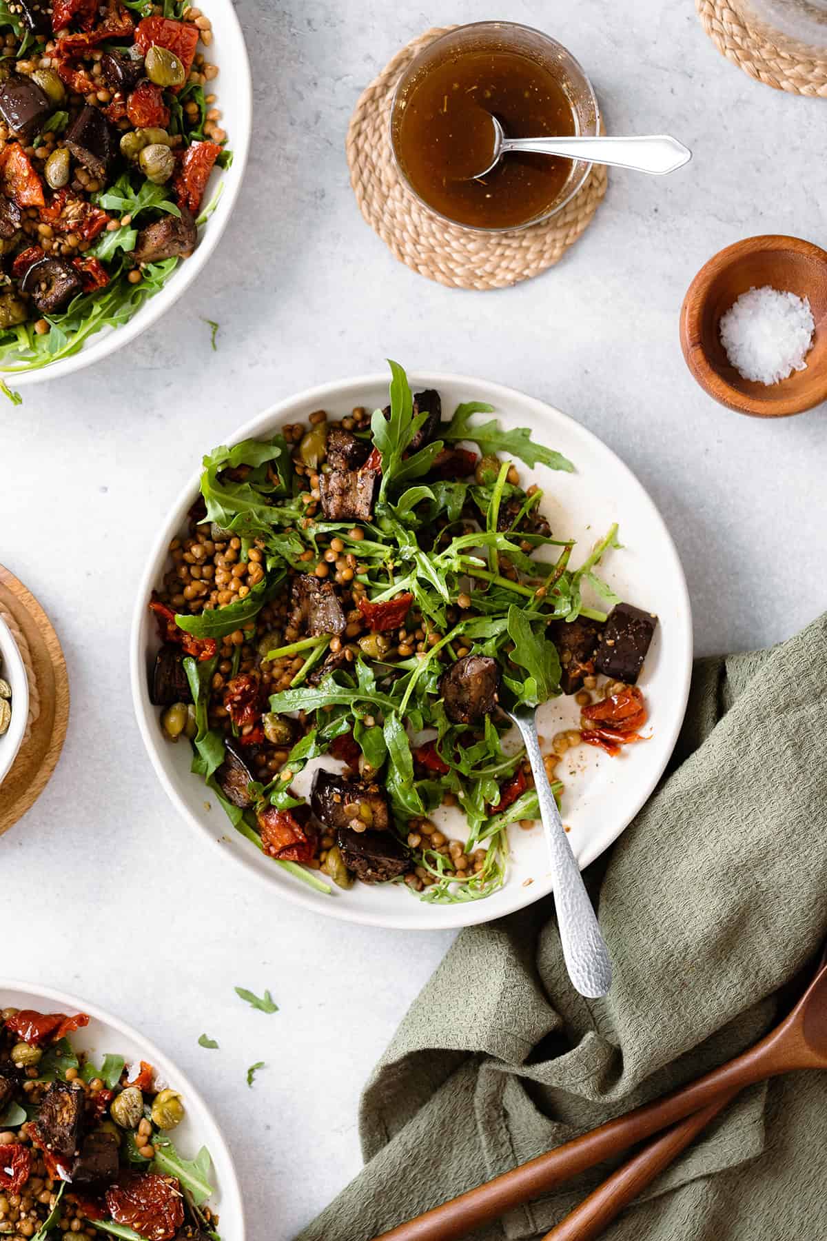 Za'atar Roasted Eggplant Lentil Salad with Sundried Tomatoes in white bowl on a grey background