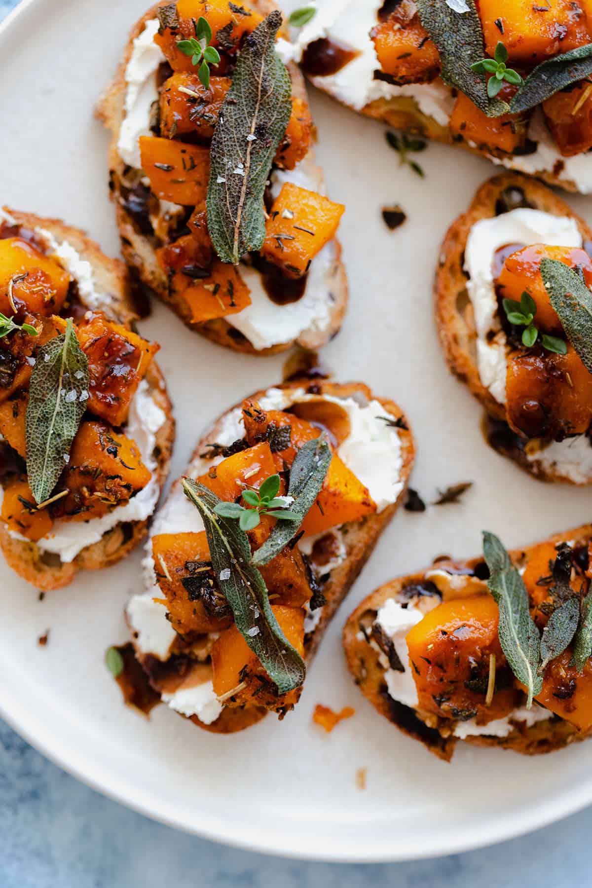 A close up shot of Butternut Squash Crostini with Goat Cheese and Fig Balsamic Glaze