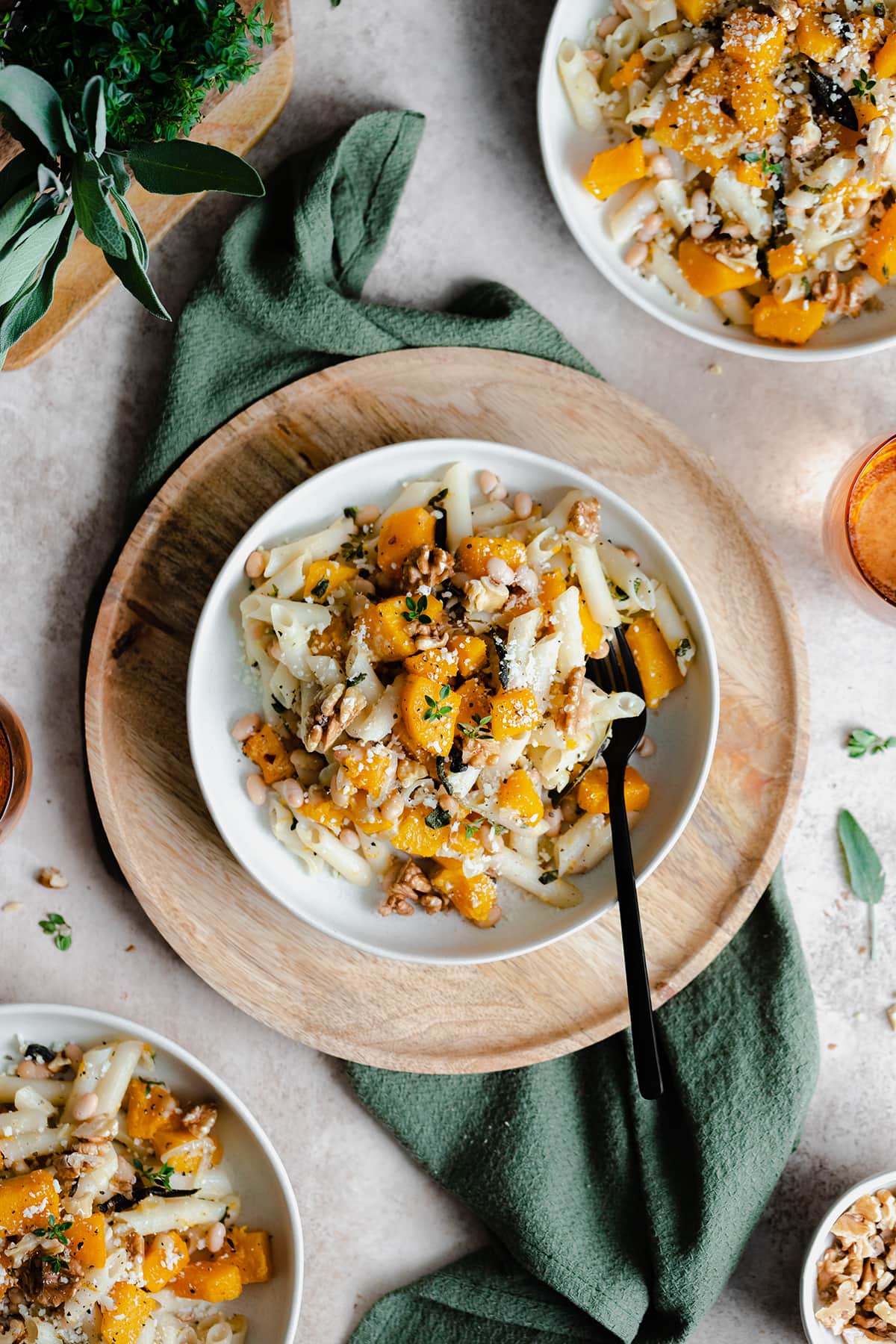 A vertical overhead shot of Butternut Squash Penne with Sage and Toasted Walnuts on a white plate