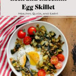 An overhead shot of Leek and Zucchini Egg Skillet on a red and white striped kitchen towel and wooden table