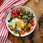 An overhead shot of Leek and Zucchini Egg Skillet on a red and white striped kitchen towel and wooden table