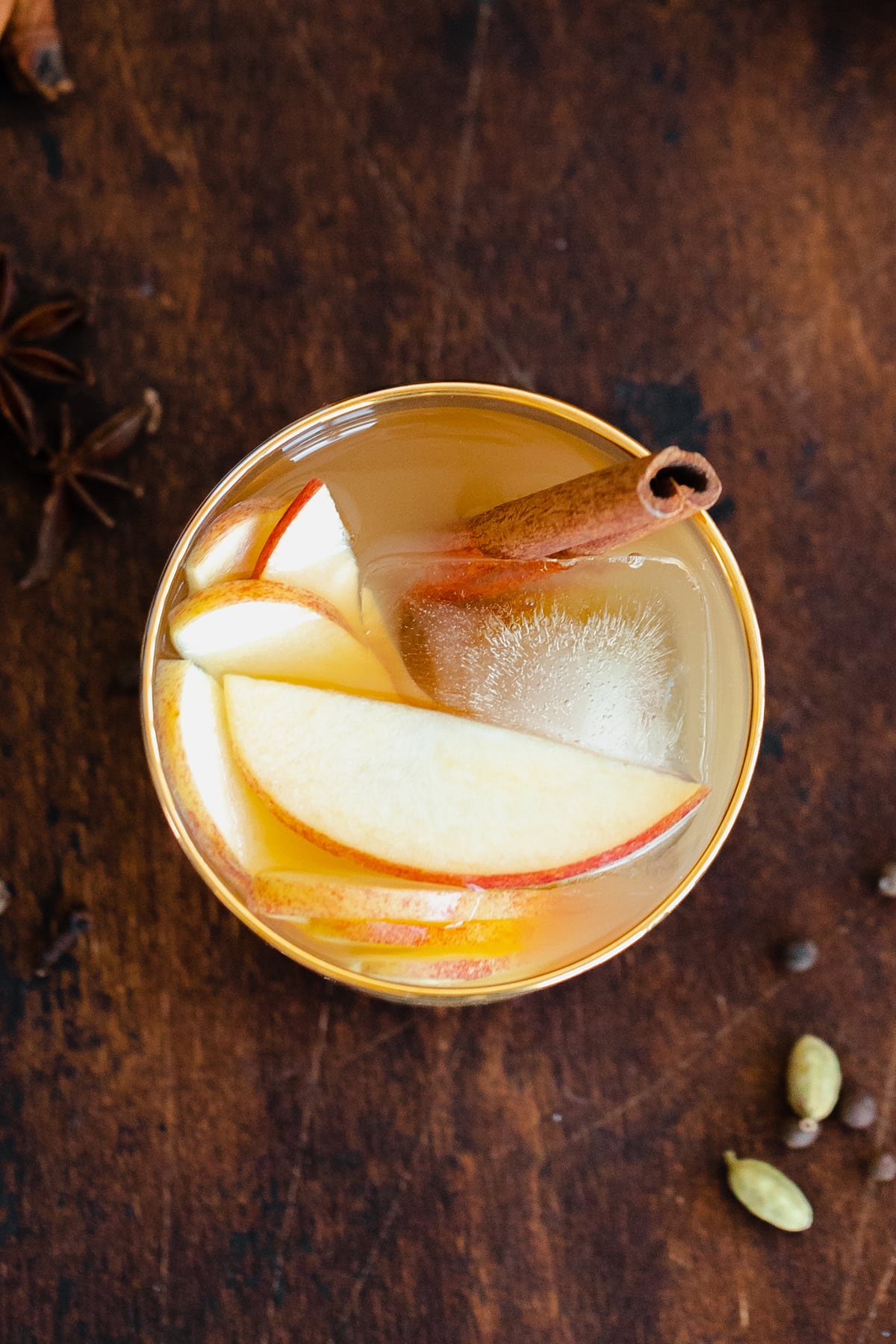 A straight on photo of Spiced Rum Apple Cider Cocktail in a short glass with a golden rim