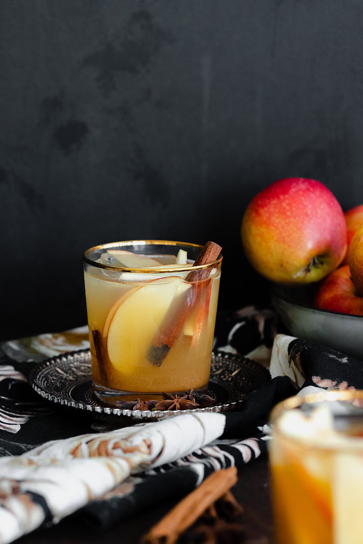 A straight on photo of Spiced Rum Apple Cider Cocktail in a short glass with a golden rim