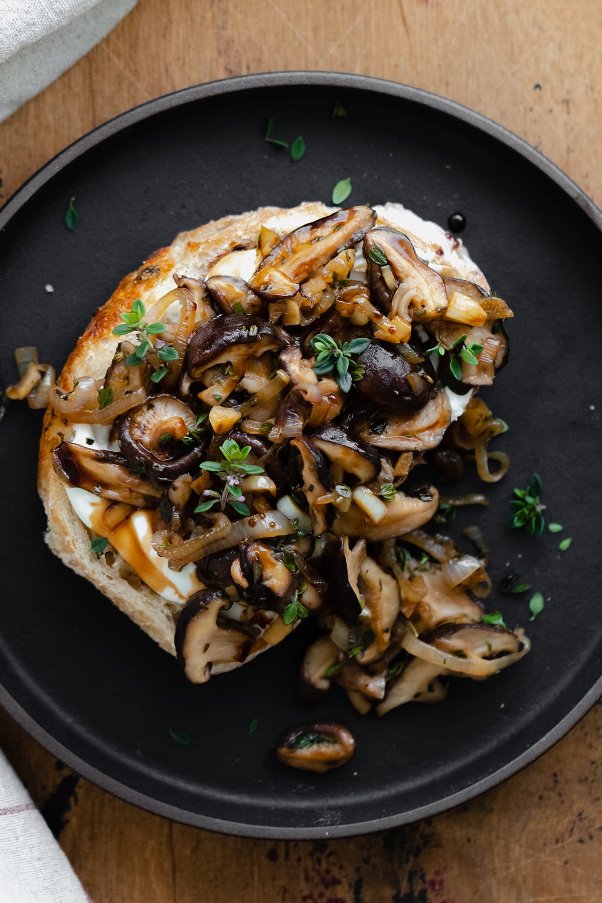 Whipped Goat Cheese Toast with Shiitake Mushroom on a black plate