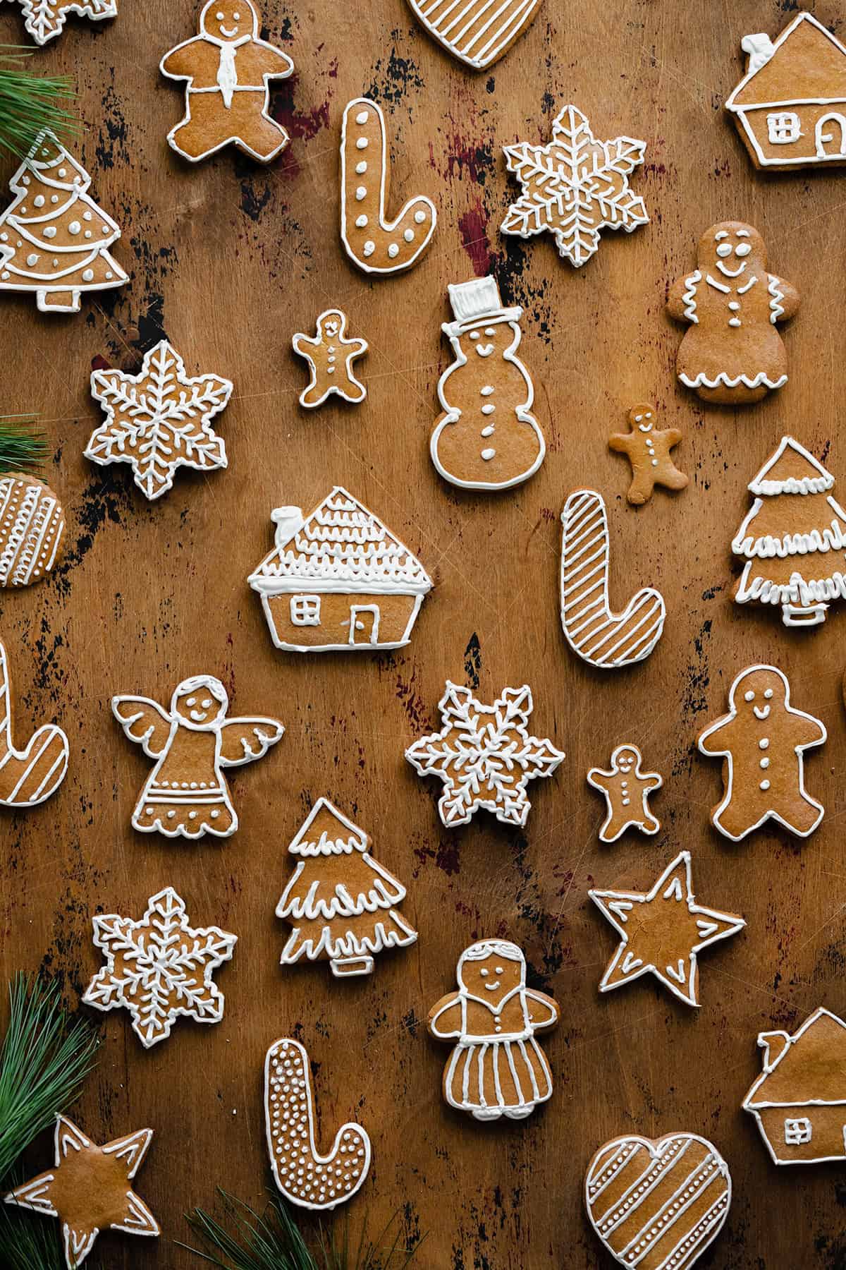 Czech Gingerbread cookies layed out evenly on a light wooden background. Decorated with white icing.