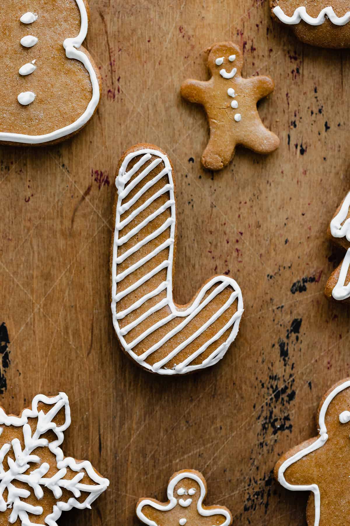 A close up of Czech Gingerbread cookies laid out evenly on a light wooden background. Decorated with white icing.