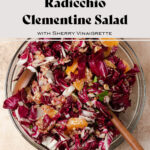 Radicchio Clementine Salad shown in a glass bowl with wooden salad spoons inserted in the bowl.