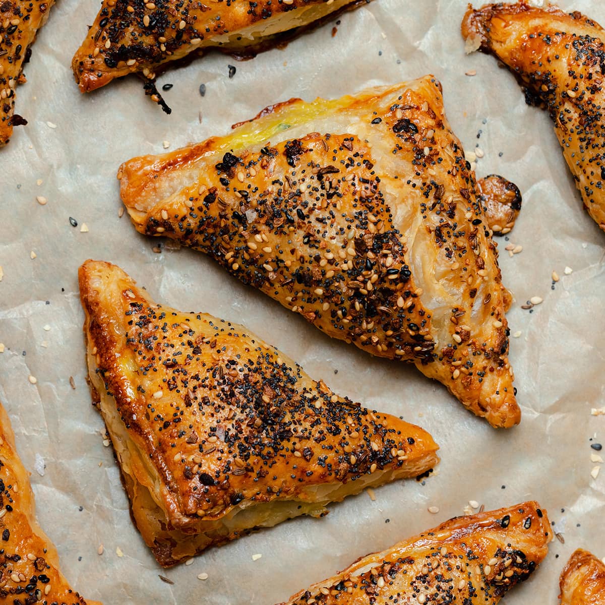 Crispy golden puff pastry triangles on parchment paper.