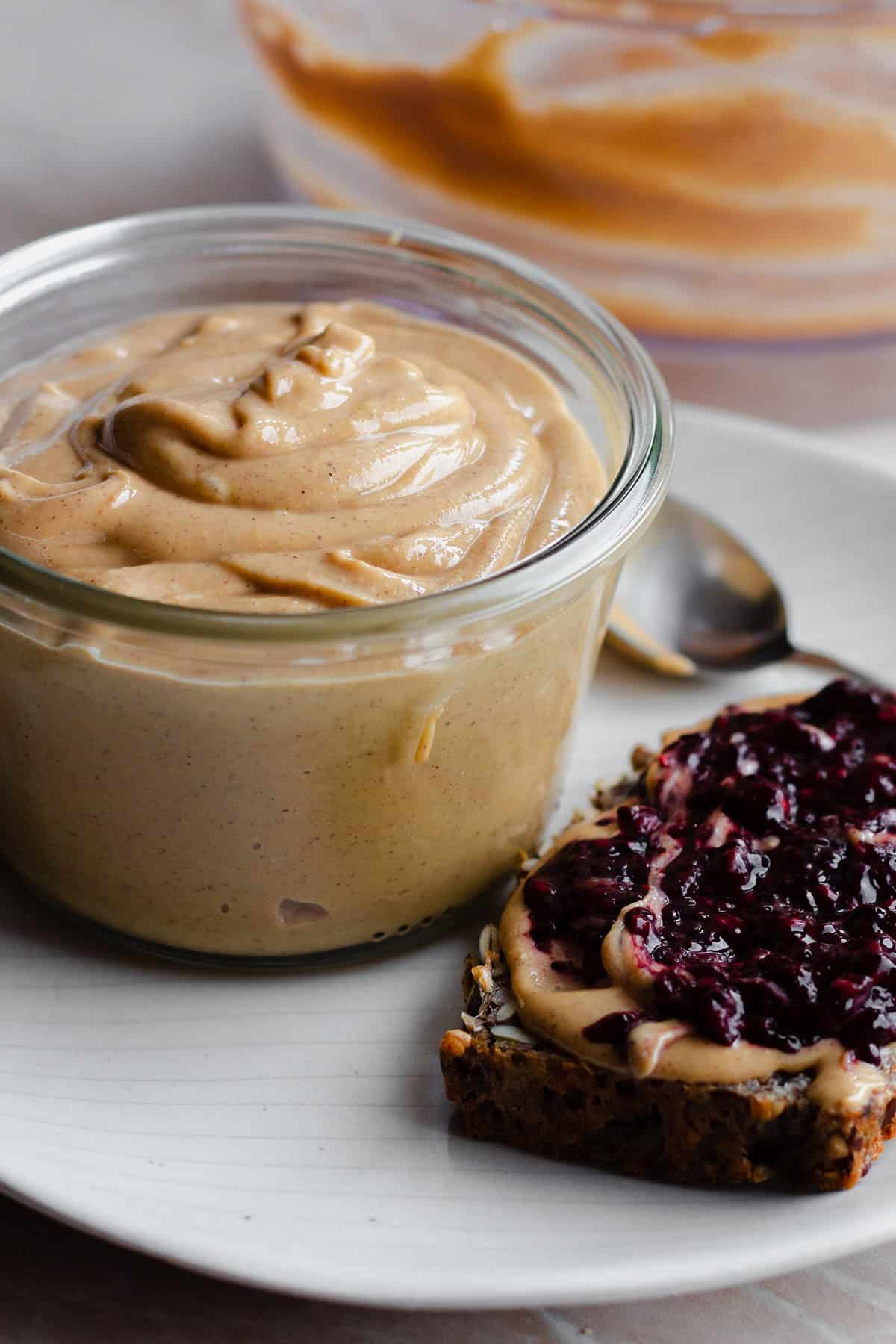 Wild Jungle Peanut Butter in a glass jar on a white plate.