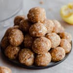 Coconut Energy Balls stacked up on a plate. Light marble background.