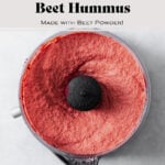 A photo of a small food processor full of the beet hummus after it's been blended.