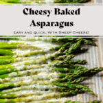 Baked asparagus spears on a sheet pan with cheese sprinkled on that has melted in the oven.