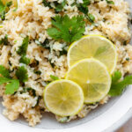 A close up of cilantro lime brown rice with lemon slices.