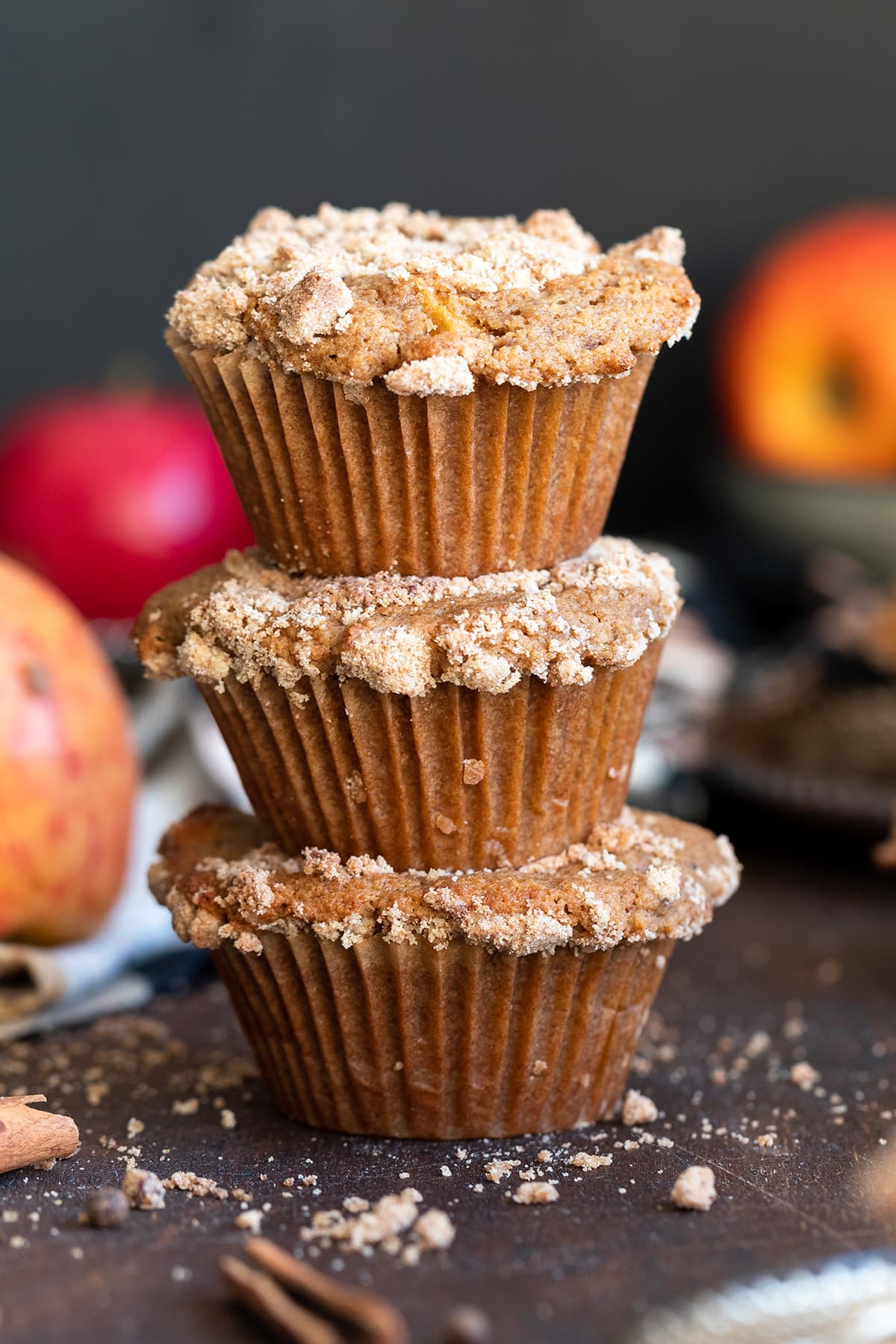 Apple muffins stacked on a wooden background.