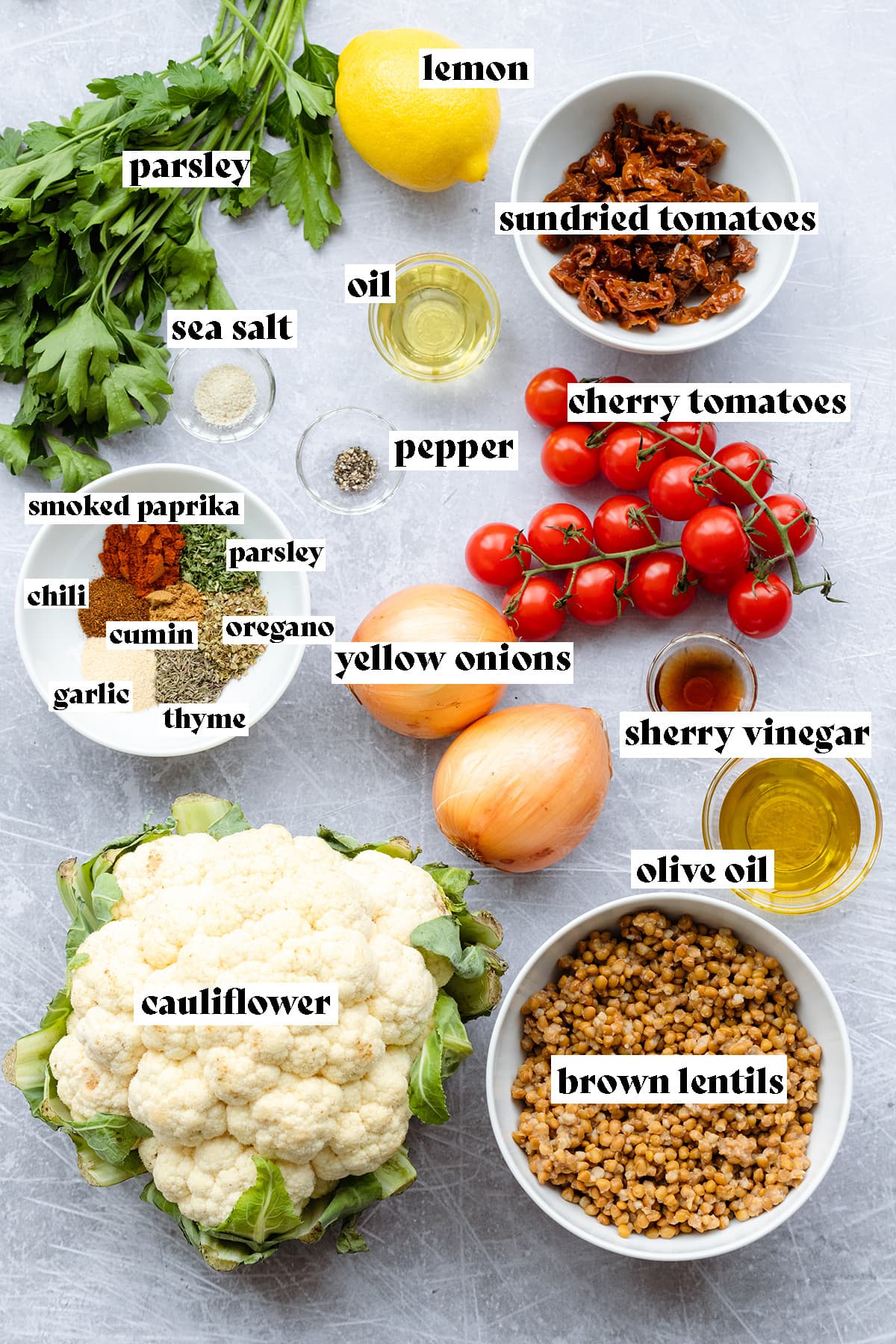 All the ingredients for cauliflower salad laid out on a metal background.