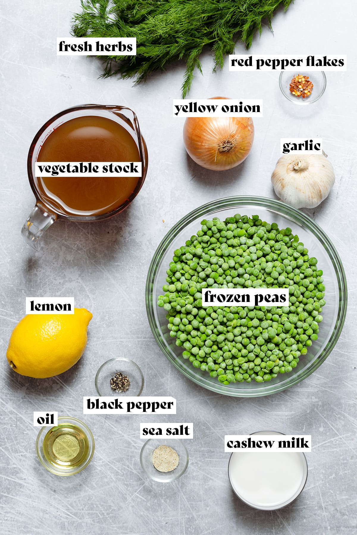Ingredients for green pea soup laid out on a scratched metal background.