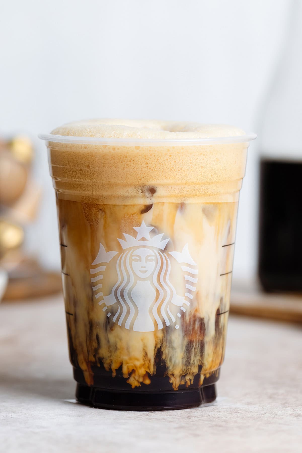 Iced shaken espresso in a Starbucks cup with milk slowly mixing in.