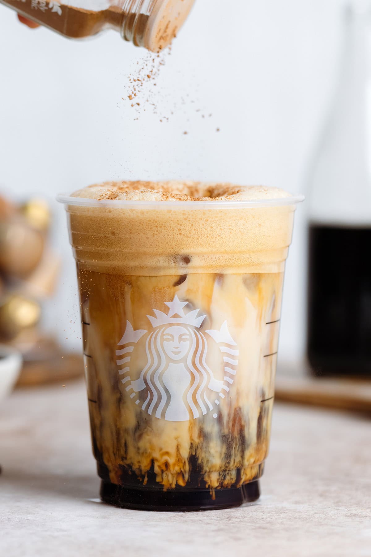 Splash of iced coffee in tall glass and coffee beans. Stock Photo