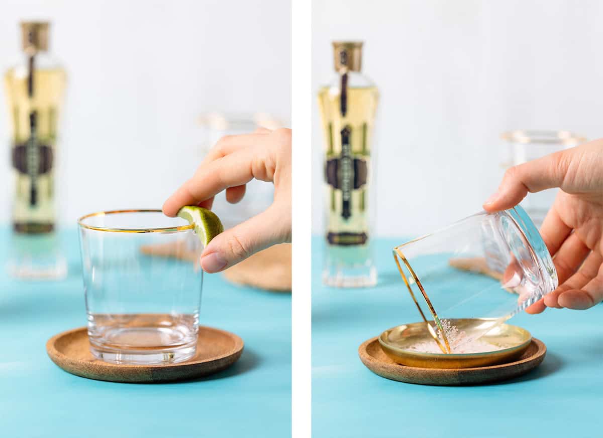 A hand running a lime wedge around a glass rim and dipping it into salt.