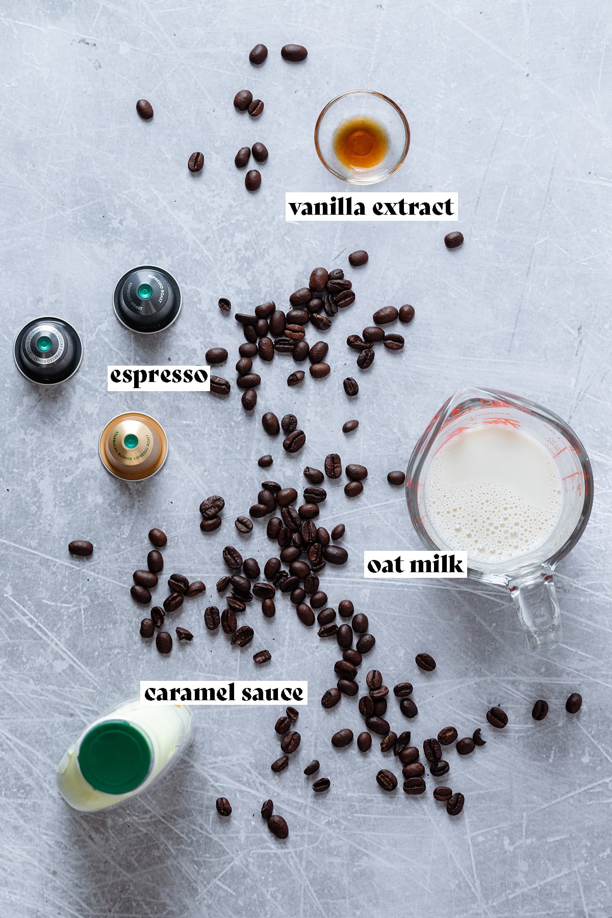 Ingredients for an iced caramel macchiato like espresso, caramel, and milk all laid out.