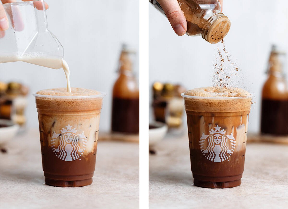 Milk being poured into a plastic Starbucks cup with frothy shaken espresso and a hand sprinkling it with cinnamon.