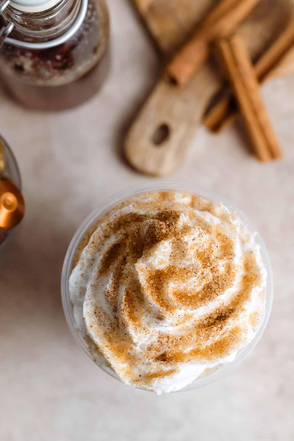 Latte with whipped cream and a coarse sugar sprinkle shot from above.