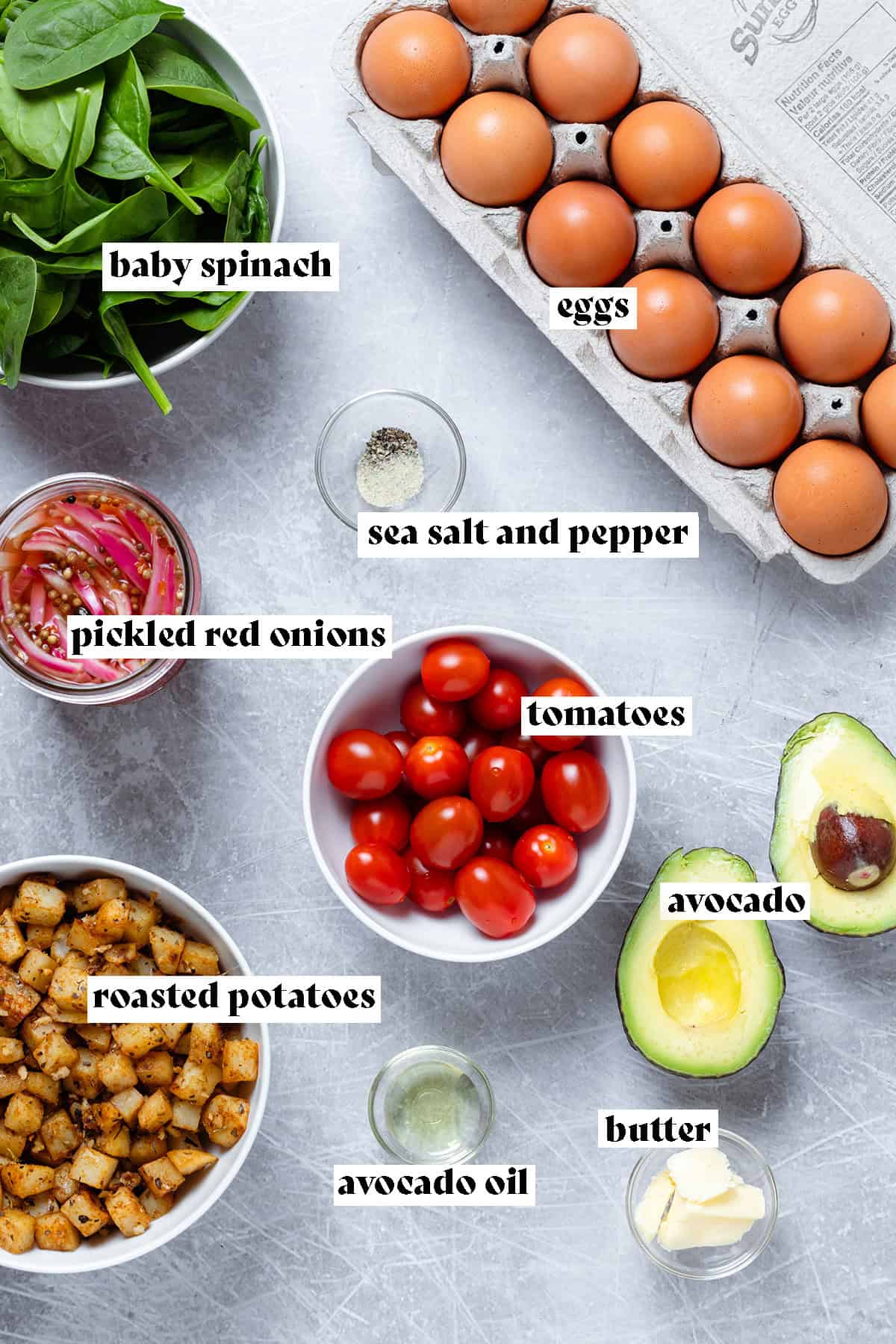 Ingredients for breakfast scramble bowl like eggs, spinach, and potatoes all laid out.