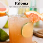 A paloma cocktail in a short glass garnished with salt, fresh lime, and grapefruit slices.