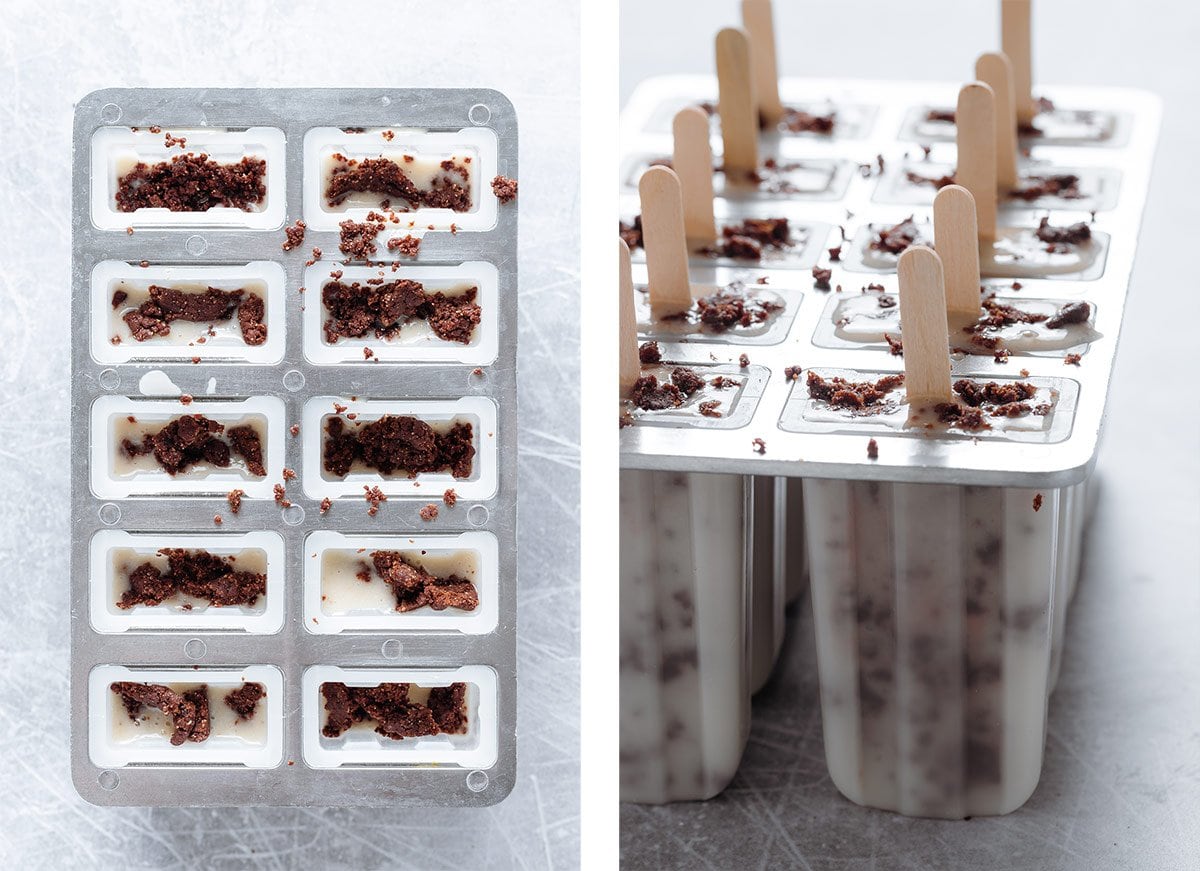 Banana ice cream and cookie dough in popsicle molds with popsicle sticks before freezing.