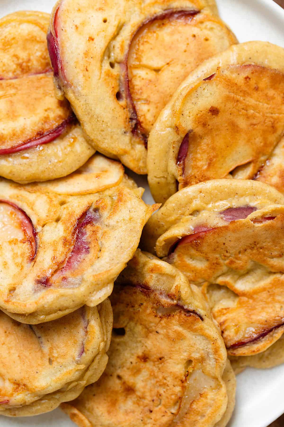 Peach stuffed pancakes laid out in a single layer on a white plate.