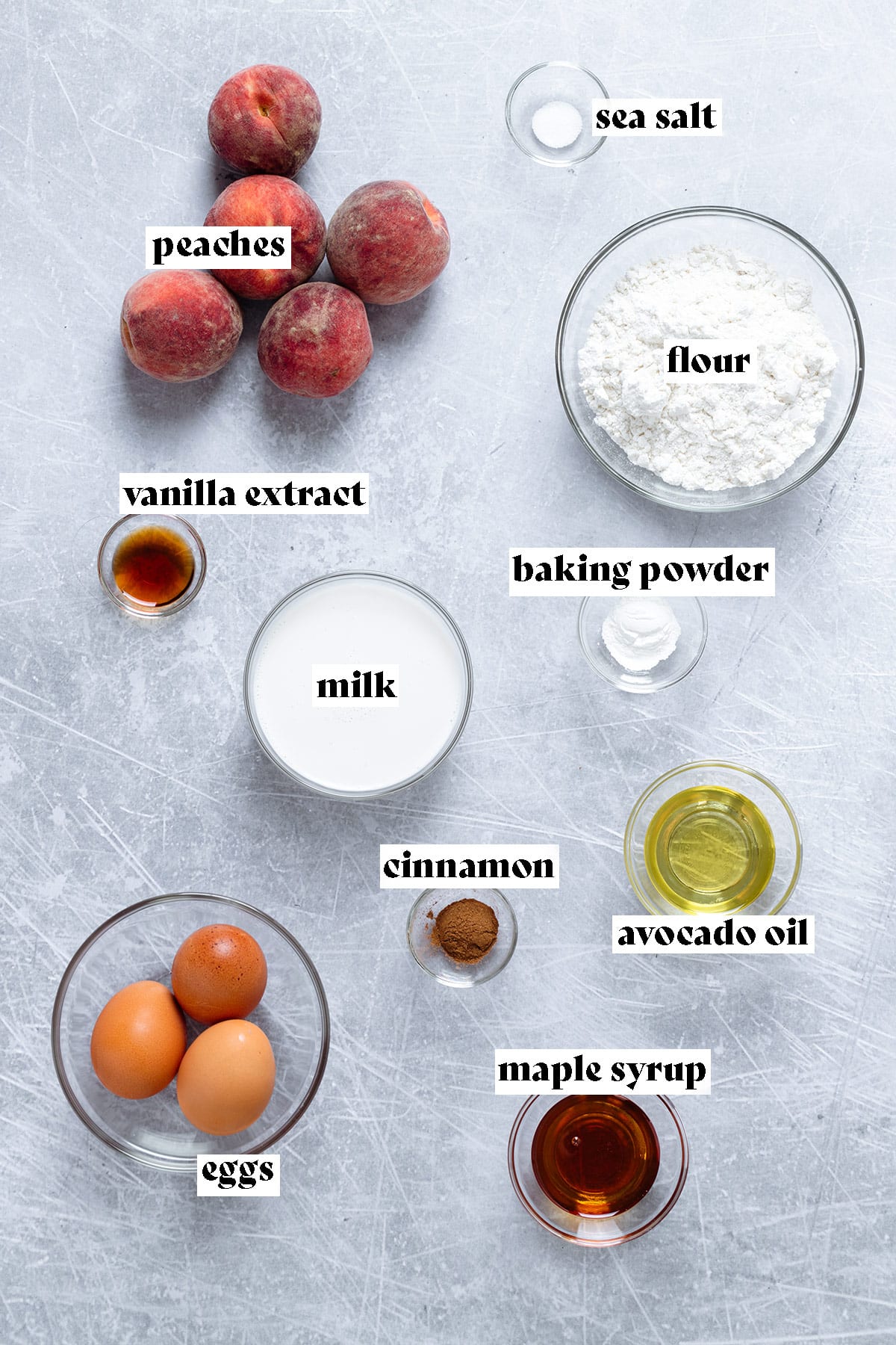 Ingredients for peach pancakes all laid out on a metal background.