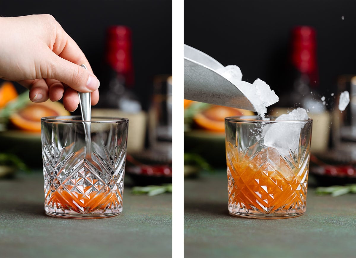 A hand mixing an old fashioned cocktail in a short glass and adding ice into it.