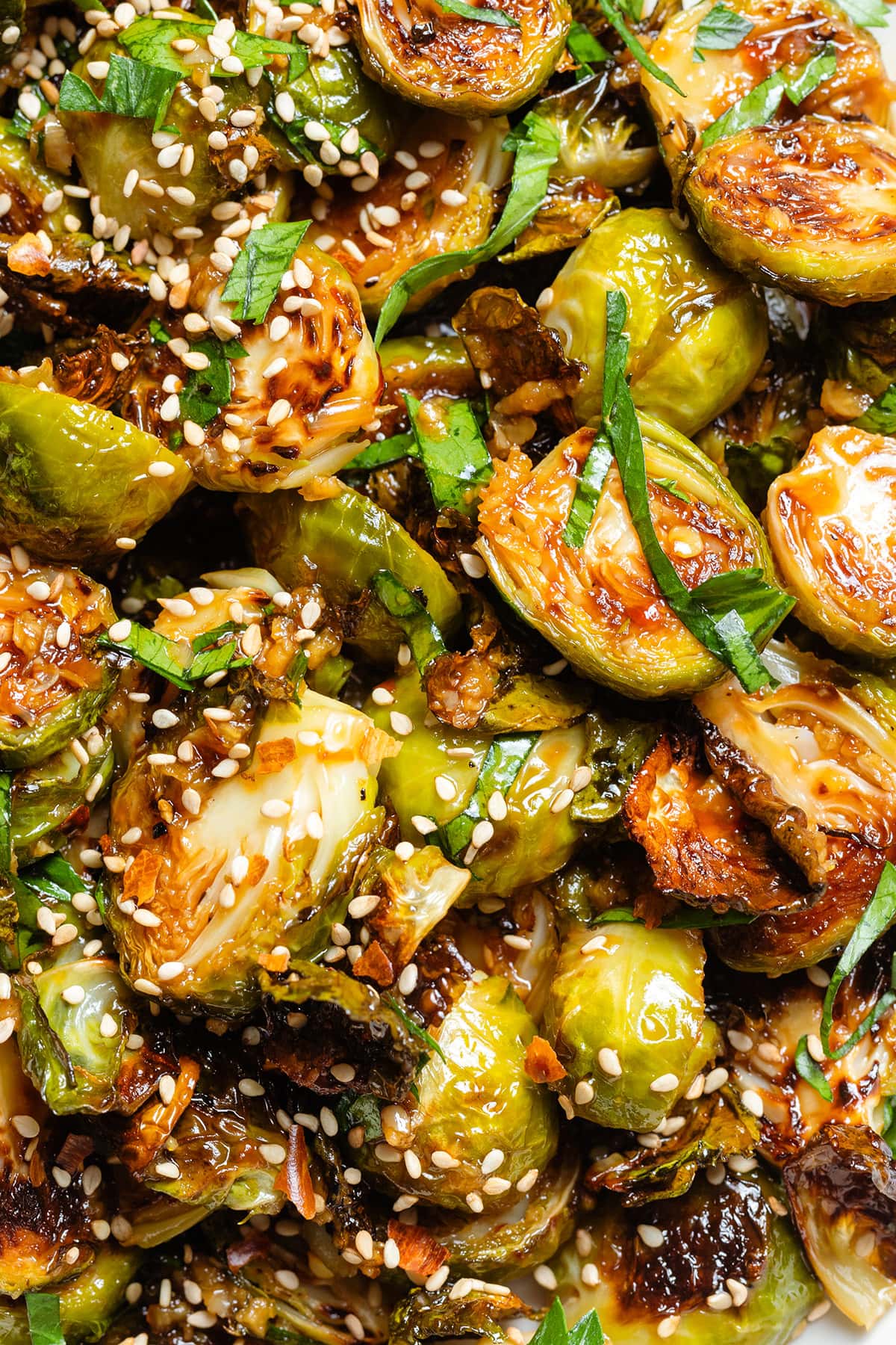 Roasted brussels sprouts topped with fresh parsley and sesame seeds.